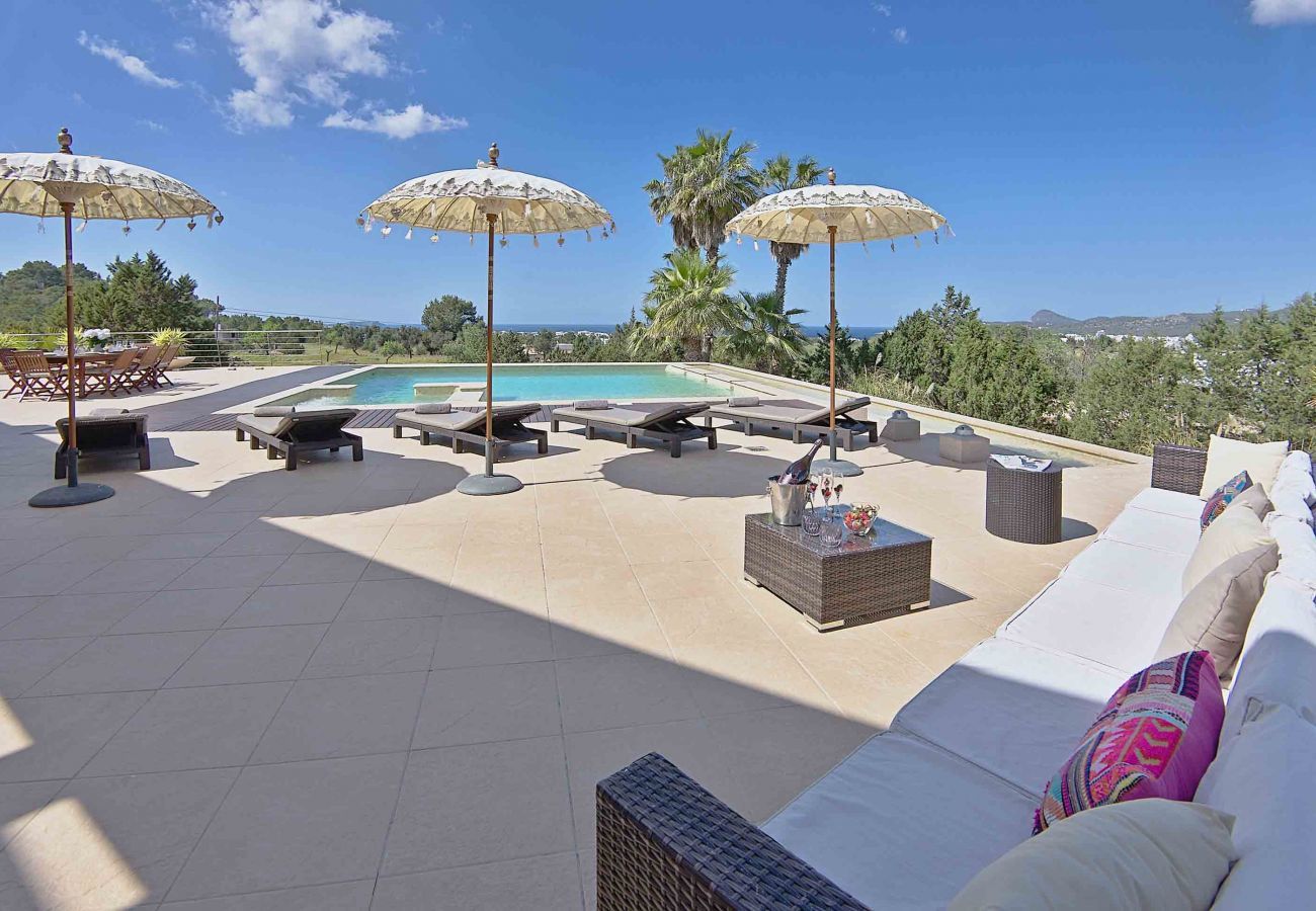 Terraza con vistas con sofás y piscina privada en villa Klark