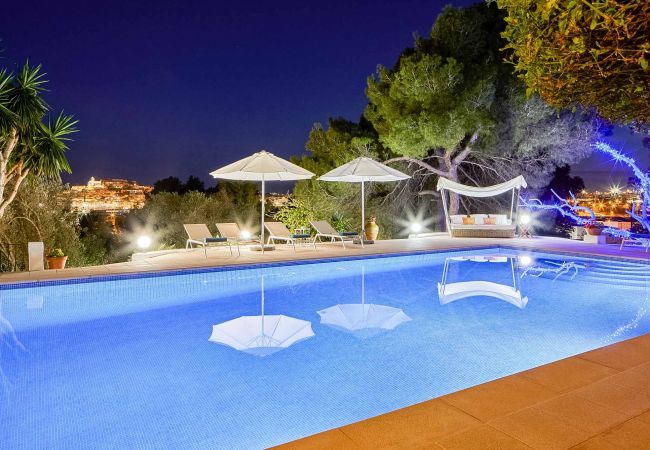 Vue sur la piscine illuminée la nuit à la Villa Elba