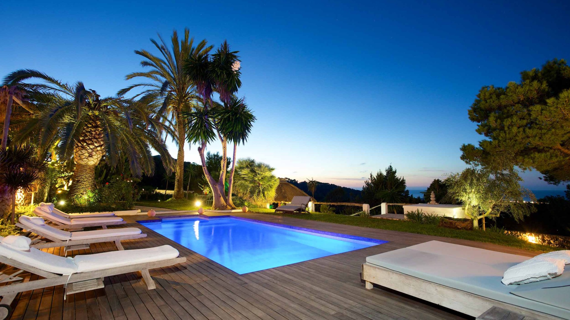 Piscina con plataforma de madera y vistas al mar