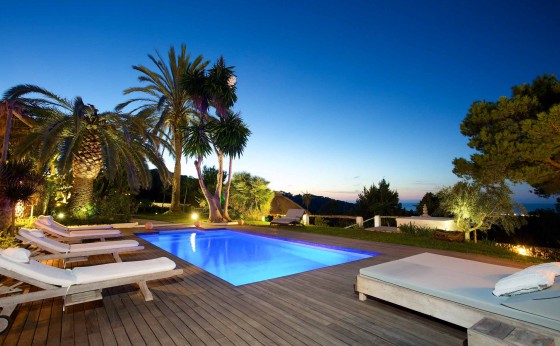 Piscina con plataforma de madera y vistas al mar