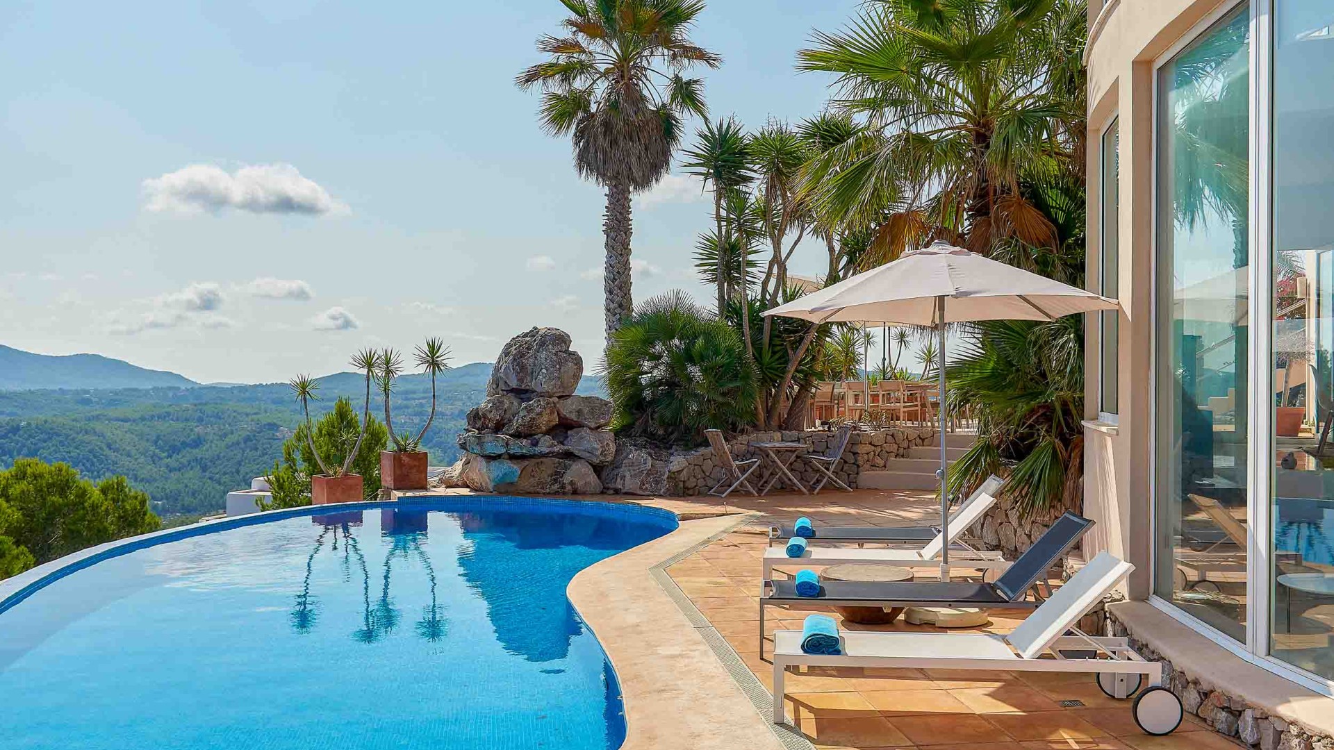 Piscina infinita con vistas a las colinas y al mar Mediterráneo