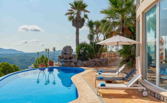 Piscina infinita con vistas a las colinas y al mar Mediterráneo