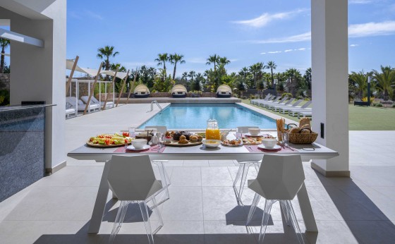 Mesa de desayuno junto a la piscina en Villa Remus