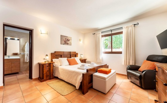 Dormitorio en Villa Marilina con decoración elegante y TV – Eivillas